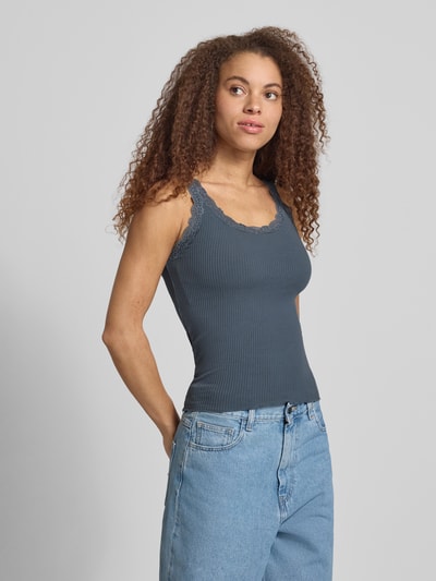 Frauenmodel trägt Slim Fit Tank Top aus Bio-Baumwoll-Mix Modell 'SARA' von Only, Optik: Unifarben, Spitze-Details, U-Ausschnitt, Feinripp-Struktur, schmale Träger, Ganzkörperansicht von vorne.