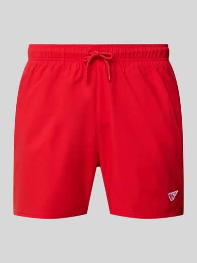 Produktfoto, rote Straight Fit Badeshorts mit Logo-Detail von Emporio Armani, elastischer Bund, Tunnelzug, glatte Textur.