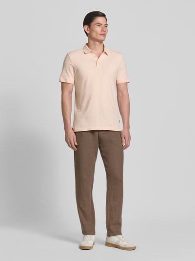 Männermodel trägt Regular Fit Poloshirt mit Knopfleiste Modell 'Carlosjuan' von JOOP! Collection aus Baumwoll-Mix mit Stretch-Anteil, Rückenlänge bei Größe M 69 cm, helle Farben, glatte Textur, Ganzkörperansicht von vorne.