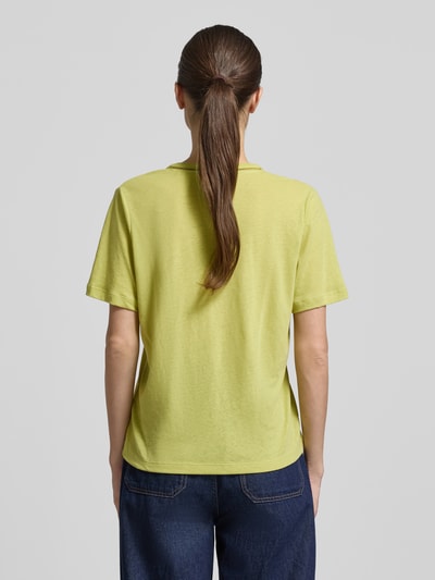 Frauenmodel trägt Regular Fit T-Shirt aus Leinen-Mix mit V-Ausschnitt von Scotch & Soda, Damen T-Shirt in Gelb, Rückenlänge 62 cm, Lochmuster, Ganzkörperansicht Rückansicht.