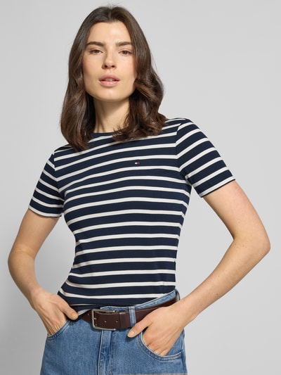 Frauenmodel trägt Slim Fit T-Shirt aus reiner Baumwolle von Tommy Hilfiger, Optik: Unifarben, Logo-Stitching, Rundhals, Kurzarm, Jersey, Ganzkörperansicht von vorne.