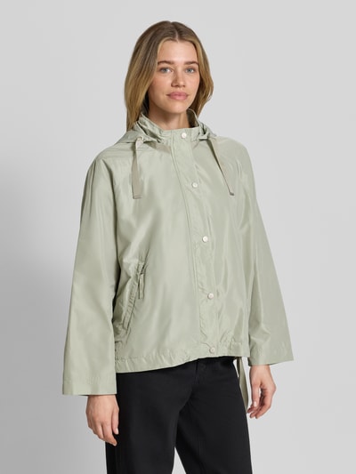 Frauenmodel trägt Jacke mit Kapuze Modell 'CICATA' von CINQUE in hellem Grün mit Kordelzug, Reißverschlusstaschen, Ganzkörperansicht von vorne.