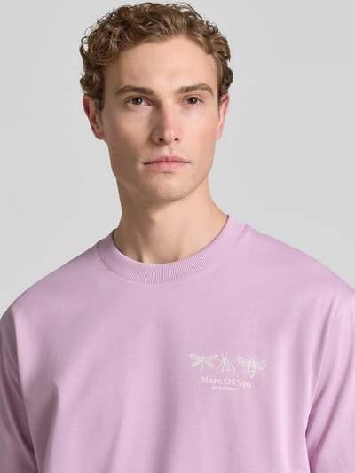 Męski model nosi Relaxed Fit T-Shirt aus reiner Baumwolle von Marc O'Polo w jednolitym kolorze, nadruk z logo, okrągły dekolt, krótki rękaw, dżersej, bawełna, zbliżenie na górną część ciała.