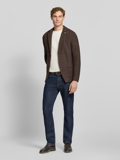 Männermodel trägt Cardigan mit Schurwoll-Anteil in Strick-Optik von Manuel Ritz, braune Farbe, mit Reverskragen und Taschen, Ganzkörperansicht von vorne, Regular Fit, Material-Mix, Rückenlänge 73 cm, Ärmellänge 65 cm.