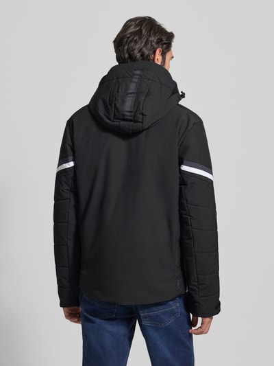 Männermodel trägt Jacke mit Kapuze Modell 'KALDOAIVI' von LUHTA in Schwarz mit Ärmelriegel, Label-Detail, Ganzkörperansicht Rückansicht.