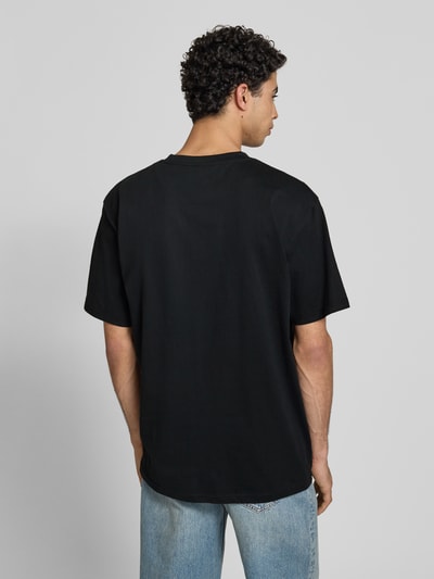 Mężczyzna nosi T-Shirt mit Label-Stitching und Rundhalsausschnitt von KARL KANI, czarna bawełna, oversized, długość tyłu 77 cm, Ganzkörperansicht Rückansicht