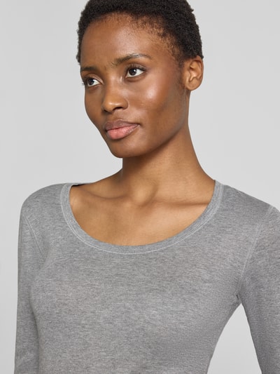 Frauenmodel trägt Slim Fit Langarmshirt aus Baumwoll-Modal-Mix Modell 'Sorana' von OPUS in Hellgrau mit glatter Textur, Nahaufnahme Oberkörper. Damen Langarmshirt von OPUS.