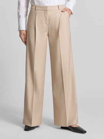 Frauenmodel trägt Weite Hose aus Viskose-Mix Modell 'HALATI' von HUGO in Beige mit Bundfalte, seitlichen Taschen, Ganzkörperansicht von vorne.