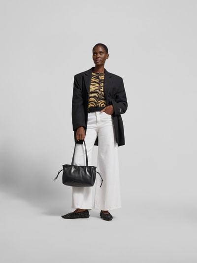 Frauenmodel trägt Shoulder Bag mit Raffungen Modell 'Ella' von Tory Burch in Schwarz mit schmalen Schulterriemen, Magnetverschluss, Reißverschlusstasche innen, Hauptfach, Ganzkörperansicht von vorne.