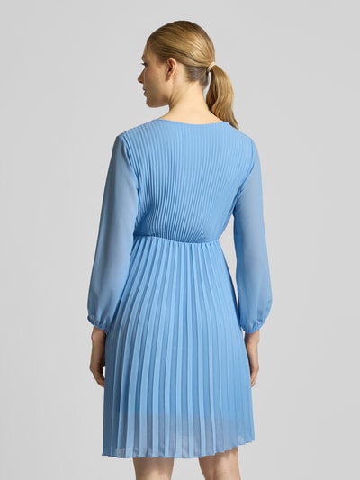 Frauenmodel trägt knielanges Kleid mit Plisseefalten Modell 'Im44sa' von ZABAIONE, Taillierter Schnitt, Wickel-Optik, hellblauer Stoff, Rückenlänge bei Größe S: 90 cm, Brustweite 38 cm, Ärmellänge 52 cm, Ganzkörperansicht Rückansicht.