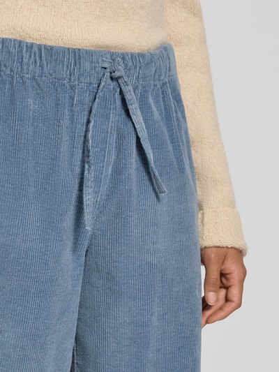 Frauenmodel trägt Relaxed Fit Weite Hose aus Baumwoll-Mix Modell 'JAIMILAA' von ARMEDANGELS, blauer Cord, Nahaufnahme Oberkörper, Damen Weite Hose.