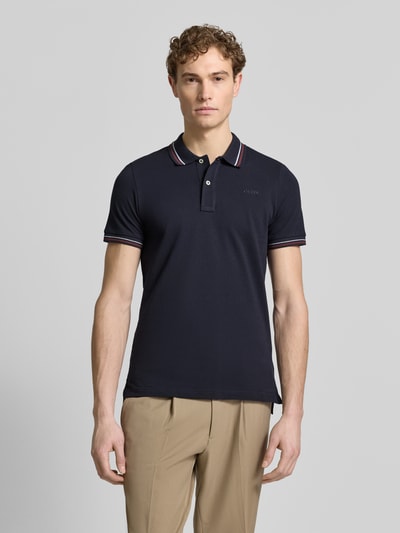 Męski model nosi Slim Fit Poloshirt mit Kontraststreifen od Geox, bawełniany miks, krój slim fit, granatowy, kołnierzyk polo, krótka listwa guzikowa, kontrastowe paski, długość tyłu w rozmiarze M: 69 cm, zdjęcie całej sylwetki z przodu.