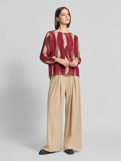Frauenmodel trägt Bluse mit Plisseefalten Modell 'Re44ynaa' von ZABAIONE in Rot-Beige, Chiffon, Rundhalsausschnitt, Ganzkörperansicht von vorne.