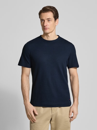 Männermodel trägt Regular Fit T-Shirt aus Baumwoll-Mix von Tom Tailor, unifarben, kurzarm, Rundhals, Piqué-Struktur, Label Patch, Ganzkörperansicht von vorne.