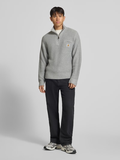 Männermodel trägt Troyer mit Brustleistentasche Modell 'DETROIT' von Carhartt Work In Progress, grauer Material-Mix, Ganzkörperansicht von vorne.