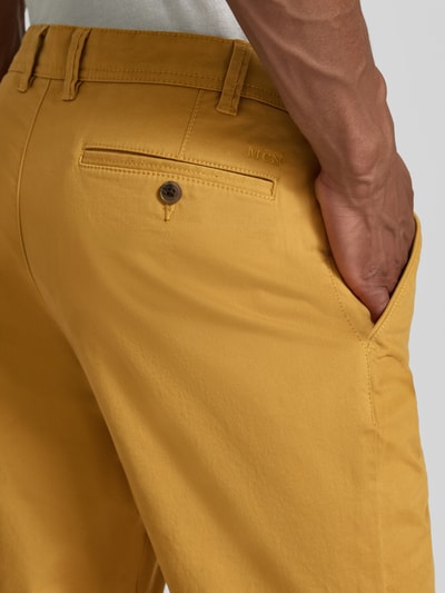 Mężczyzna nosi Straight Fit Hose mit Gesäßtaschen von MCNEAL, żółta bawełna z kieszeniami, Szerokość w rozmiarze 50: 46 cm, długość nogawki 83 cm, detal tylnej części spodni, zbliżenie
