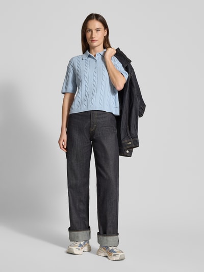 Vrouwenmodel draagt Slim Fit Poloshirt in Strick-Optik van JAKE*S STUDIO WOMAN in lichtblauw, katoen, polokraag, korte knoopsluiting, geribde boorden, slim fit, volledig lichaamsaanzicht van voren.