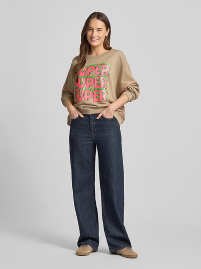Frauenmodel trägt Oversized Sweatshirt mit gerippten Abschlüssen von miss goodlife in Beige, Statement-Print, Reine Baumwolle, Ganzkörperansicht von vorne.