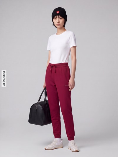 Vrouwenmodel draagt Regular Fit Jogpant uit katoenmix model 'Hugo ID Pant' van HUGO in bordeauxrood, dames jogpant, volledige lichaamsvooraanzicht, KI-gemodificeerde afbeelding
