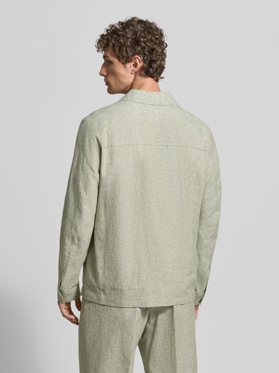 Männermodel trägt Relaxed Fit Overshirt aus Leinen-Mix mit Kentkragen von MCNEAL in hellgrün, Leinen-Baumwoll-Mix, Rückenansicht, Ganzkörperansicht Rückansicht. Rückenlänge bei Größe M: 69 cm, mit Knopfleiste, Brusttaschen und Sportmanschetten.