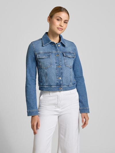 Frauenmodel trägt Jeansjacke mit Brusttaschen Modell 'NEWVICKY' von Mango, Slim Fit, blauer Baumwoll-Elasthan-Mix, Ganzkörperansicht von vorne.