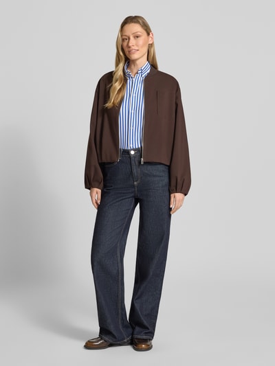 Vrouwenmodel draagt 'Hemdbluse mit Knopfleiste' van Polo Ralph Lauren in blauw-witte strepen, regular fit, puur katoen, button-down-kraag, label-stitching, ruglengte maat S 67 cm, mouwlengte 62 cm, geheellichaamsaanzicht van voren.