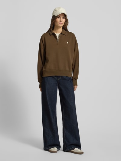 Kobiece model nosi Bluza z wyhaftowanym logo Sweatshirt mit Label-Stitching od Polo Ralph Lauren z mieszanki bawełny, luźny krój, kołnierzyk polo, krótki zamek błyskawiczny, prążkowane wykończenia, widok całej sylwetki z przodu.