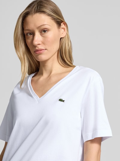 Frauenmodel trägt Relaxed Fit T-Shirt aus reiner Baumwolle von Lacoste, Optik: Unifarben, Logo-Stitching, V-Ausschnitt, Nahaufnahme Oberkörper.
