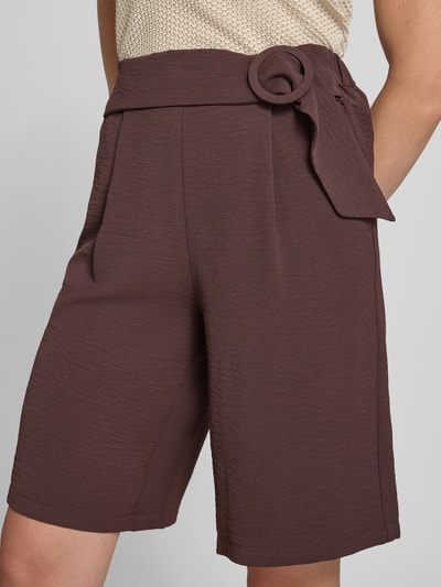 Frauenmodel trägt Bermudas mit Gürtel und französischen Eingrifftaschen von zero, Loose Fit, strukturierte Textur, Nahaufnahme Oberkörper.
