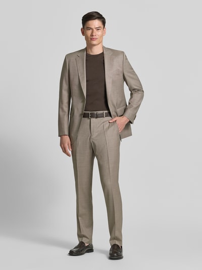 Männermodel trägt Slim Fit Anzug aus Schurwoll-Mix Modell 'HUGE' von BOSS in hellbraun, feine Textur, Ganzkörperansicht von vorne, Herren Anzug von BOSS.