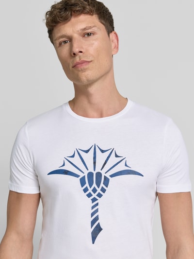 Männermodel trägt T-Shirt mit Rundhalsausschnitt Modell 'Alerio' von JOOP! Collection, weiße Baumwolle, blaues Logo, Nahaufnahme Oberkörper