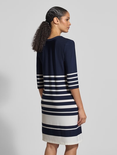 Männermodel trägt Knielanges Kleid mit V-Ausschnitt von Christian Berg Woman Selection, Mieszanka materiałów z dodatkiem streczu, taliowany krój, długość do kolan, dekolt w serek, rękaw o dł. 3/4, długość tyłu w rozmiarze 36: 92 cm, szerokość w rozmiarze 36: 44 cm, długość rękawa w rozmiarze 36: 43 cm, granatowe i białe pasy, miękka i gładka faktura materiału, całkowity widok z tyłu