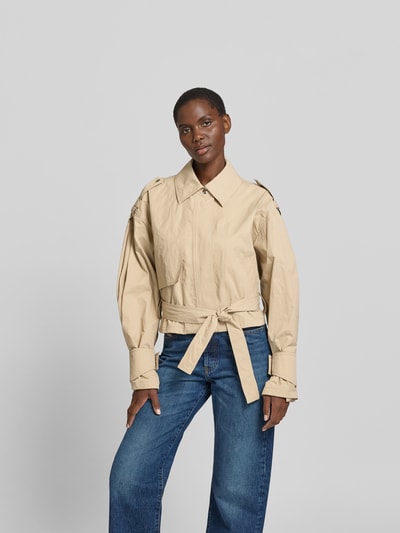 Frauenmodel trägt Jacke aus reiner Viskose Modell 'ZYNIA' von IRO in Beige, lockerer Schnitt, Bindegürtel, Eingrifftaschen, Ganzkörperansicht von vorne, Rückenlänge 52 cm, Brustweite 52 cm, Ärmellänge 61 cm bei Größe 36.