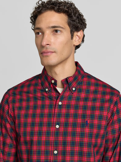 Männermodel trägt Custom Fit Freizeithemd aus reiner Baumwolle von Polo Ralph Lauren, rot-grün kariert, Nahaufnahme Oberkörper.