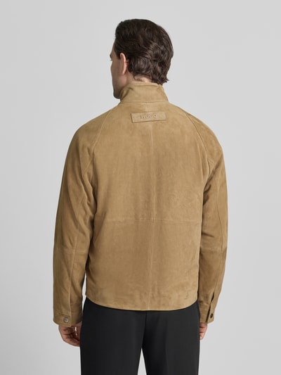 Męski model nosi Regular Fit Lederjacke aus echtem Ziegenleder Modell 'LORIDGE' od HUGO, beżowy, welurowa faktura, widok z tyłu.