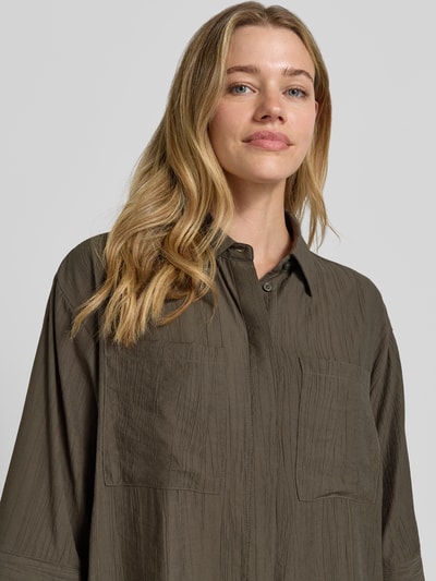 Frauenmodel trägt Regular Fit Bluse aus Viskose-Mix mit 3/4-Arm Modell 'Forna' von OPUS, Hemdblusenkragen, verdeckte Knopfleiste, Brusttaschen, texturierte Oberfläche, Nahaufnahme Oberkörper.