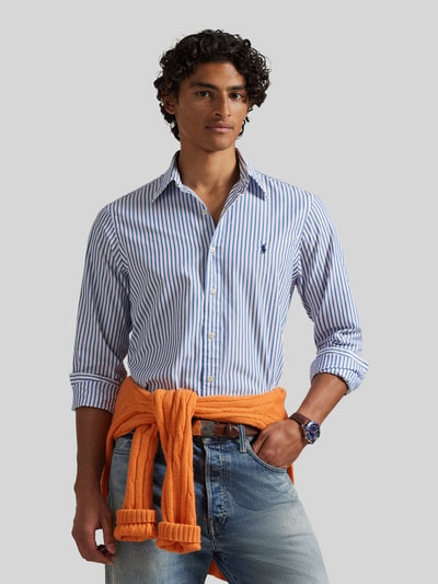 Męski model nosi Custom Fit Freizeithemd aus reiner Baumwolle von Polo Ralph Lauren, efekt: wzór w paski, krój custom fit, kołnierzyk typu kent, jednorzędowa listwa guzikowa, wzór w paski, wyhaftowane logo, zapięcie: jednorzędowa listwa guzikowa, rękawy: długi rękaw, zakończenie rękawów: mankiet, dół lekko zaokrąglony, materiał: bawełna, Ganzkörperansicht z przodu.