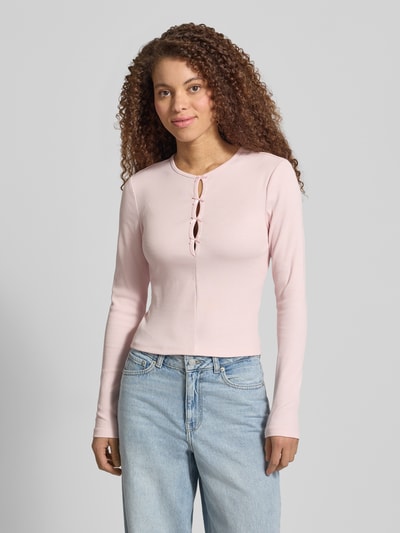 Frauenmodel trägt Slim Fit Langarmshirt aus Baumwoll-Mix Modell 'FEMKE' von Only, unifarben, Feinripp, Rundhals, Schlaufen, Ganzkörperansicht von vorne.