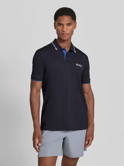 Männermodel trägt Regular Fit Poloshirt aus Baumwoll-Mix Modell ''Paddy Pro'' von BOSS, dunkelblau mit weißen Akzenten, Nahaufnahme Oberkörper, Herren Poloshirt von BOSS Green.