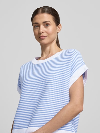 Frauenmodel trägt T-Shirt aus reiner Baumwolle in Strick-Optik Modell 'Kipe' von JOOP!, hellblau-weiß gestreift, lockere Passform, Nahaufnahme Oberkörper.