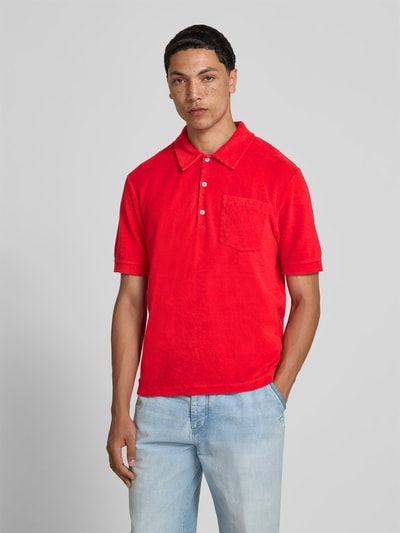 Männermodel trägt Regular Fit Poloshirt aus Baumwoll-Mix von Closed in Rot mit Polokragen und Brusttasche, Ganzkörperansicht von vorne.
