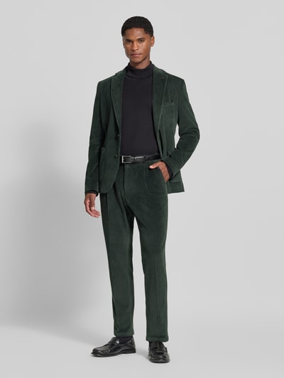 Männermodel trägt spodnie Slim Fit aus mieszanka bawełny w imitacja sztruksu Modell 'Cliffer' von Zuitable, ciemnozielone, wpuszczane kieszenie, kieszeń z tyłu, zapięcie na guzik i zamek błyskawiczny, Szerokość w rozmiarze 50: 37 cm, Długość wewnętrzna nogawki w rozmiarze 50: 76 cm, Ganzkörperansicht von vorne.