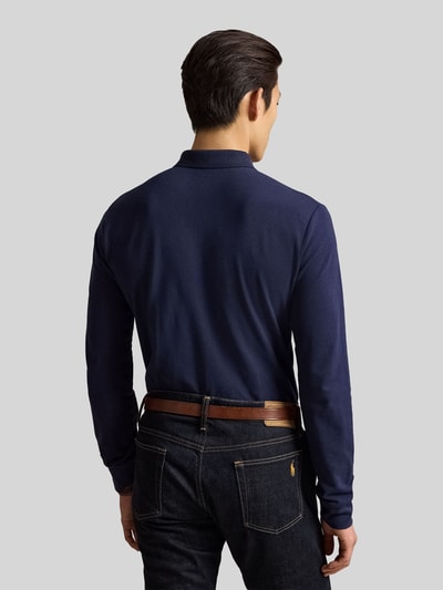 Männermodel trägt Regular Fit Poloshirt mit Logo-Stitching von Polo Ralph Lauren in Dunkelblau, kombiniert mit Jeans, Ganzkörperansicht Rückansicht, Herren Pullover von Polo Ralph Lauren.