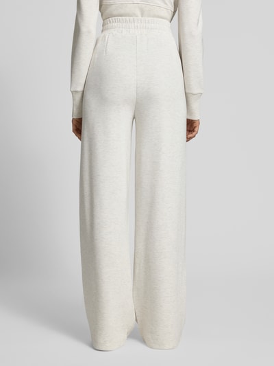 Kobiece modelka ma na sobie Wide Leg Pants aus Viskose-Mix mit elastischem Bund od VARLEY, kremowy kolor, wpuszczane kieszenie, długość wewnętrzna nogawki 84 cm, szerokość w rozmiarze S: 36 cm, mieszanka wiskozy z dodatkiem streczu, fason wide fit, widok całej sylwetki z tyłu.