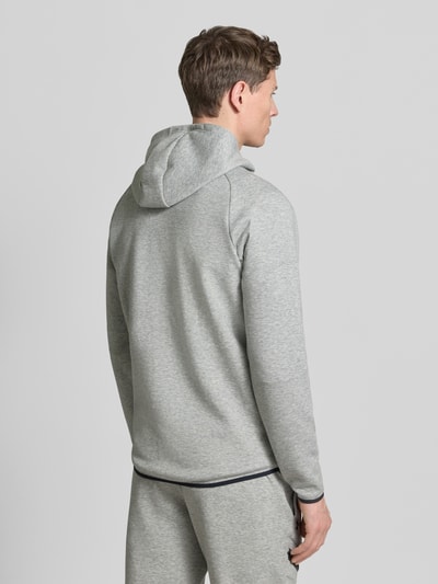 Männermodel trägt Regular Fit Jacke mit Kapuze Modell 'Unstoppable' von Under Armour in Hellgrau, Baumwoll-Mix, Rückenansicht, Ganzkörperansicht.