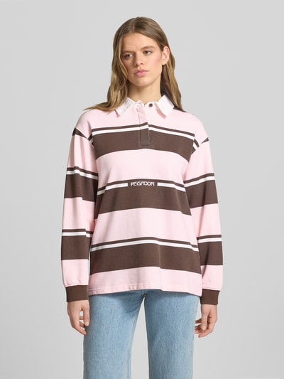Frauenmodel trägt Pegador Sweatshirt mit Polokragen Modell 'MORELLA' aus Reine Baumwolle, Loose-Fit, Logo-Print, rosa-braune Streifen, Ganzkörperansicht von vorne.