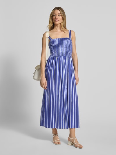 Frauenmodel trägt Midikleid im Allover-Look mit Smok-Details von Marc Cain, blau-weiße vertikale Streifen, Baumwolle, Ganzkörperansicht von vorne.