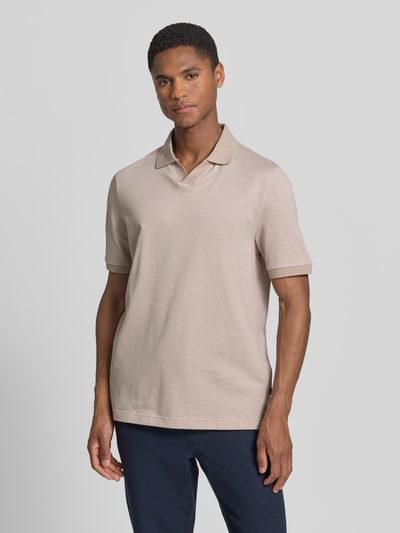 Männermodel trägt Regular Fit Poloshirt aus Baumwolle mit V-Ausschnitt von MAERZ Muenchen in Beige mit Label-Detail, Ganzkörperansicht von vorne. Rückenlänge bei Größe 50: 71 cm.