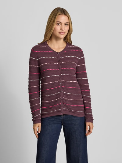 Frauenmodel trägt Cardigan aus reiner Baumwolle von Christian Berg Woman, dunkel mit Streifen in Bordeaux, Rosa und Weiß, enganliegende Passform, Rundhalsausschnitt, lange Ärmel, Knopfleiste, Ganzkörperansicht von vorne.