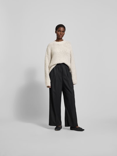 Frauenmodel trägt Pullover mit gerippten Abschlüssen von black palms im Alpaka-Woll-Mix, Oversized, Rundhalsausschnitt, cremefarben, Ganzkörperansicht von vorne.
